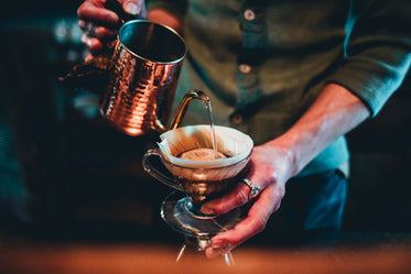 咖啡师从铜壶里倒咖啡
