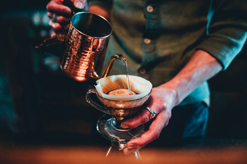 咖啡师从铜壶倒咖啡