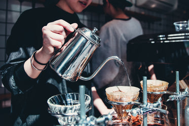 barista pours over coffee at cafe