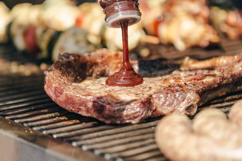 bbq sauce going onto grilled steak