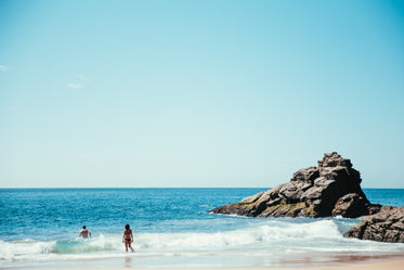 beach goers swim in ocean