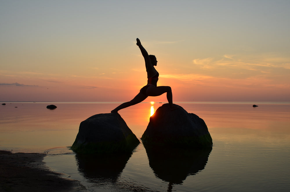 beach yoga on rocks at sunset