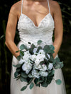 vestido de casamento frisado e buquê de flores brancas