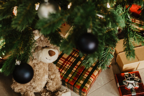 ursinho e presentes sob a árvore de natal
