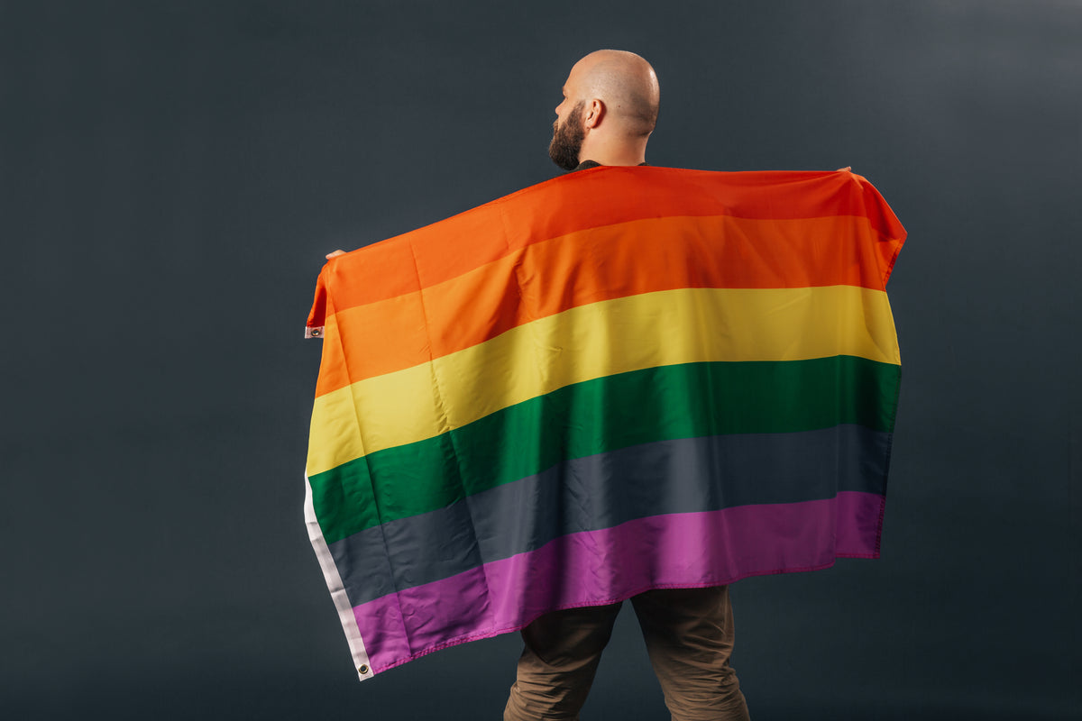 bearded man holding pride flag