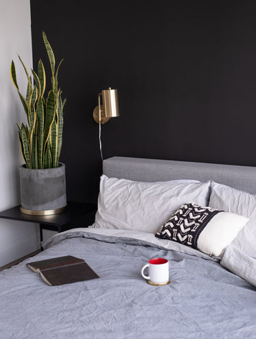 bed with a novel and mug set on top of the duvet