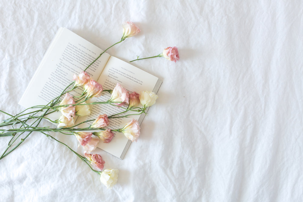bed with book and flowers