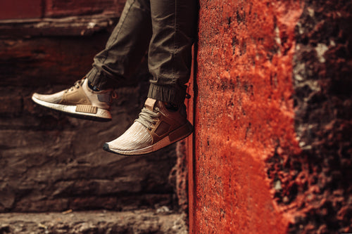 beige trainers in front of red wall