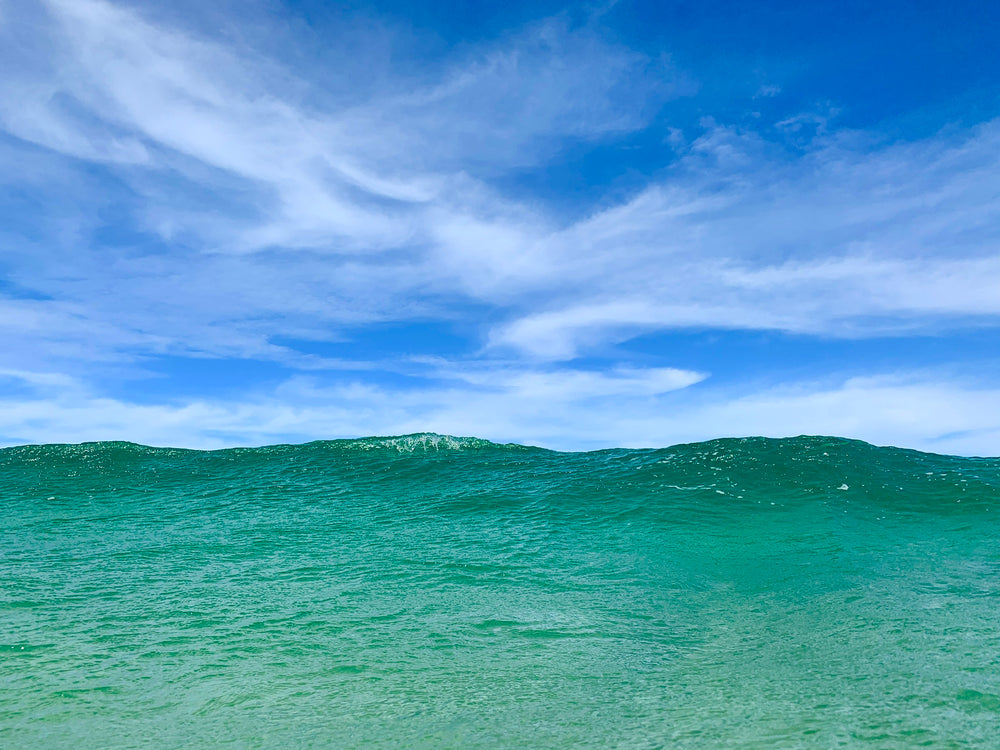 big ocean wave under blue sky