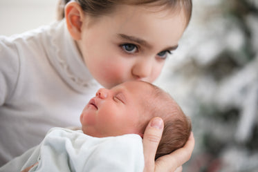 big sister kisses baby