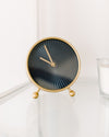 black and gold clock sits on a white table