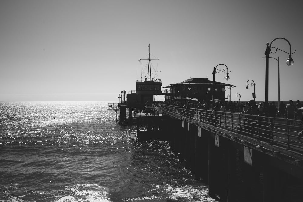 black and white busy pier overlooking the water
