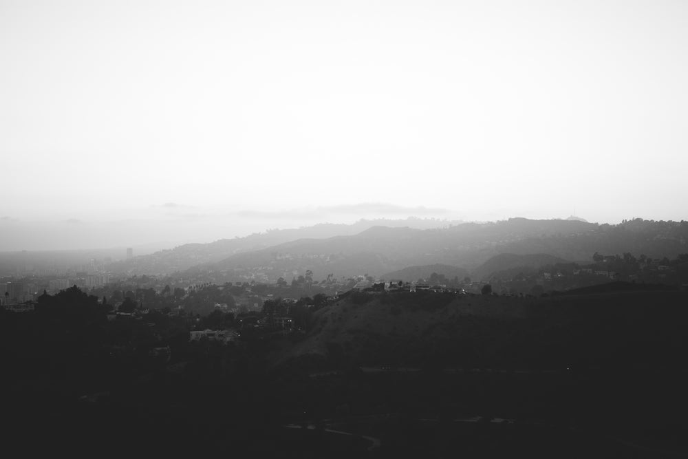 black and white fog rolling over hills and trees