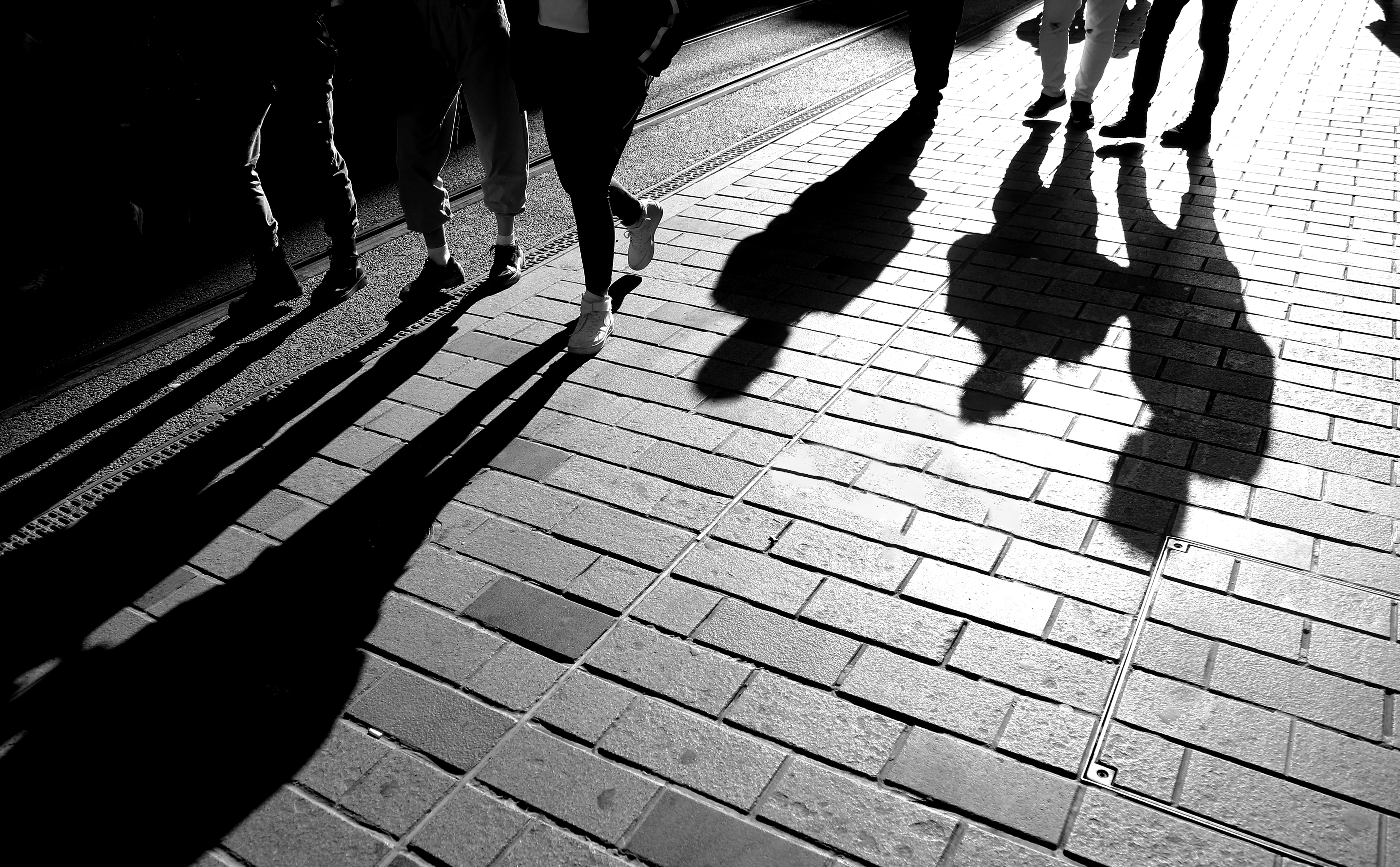 Black And White Legs Walking On A Cobblestone Road