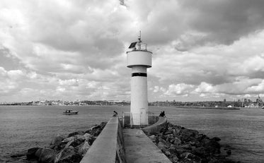 black and white lighthouse overlooking calm water