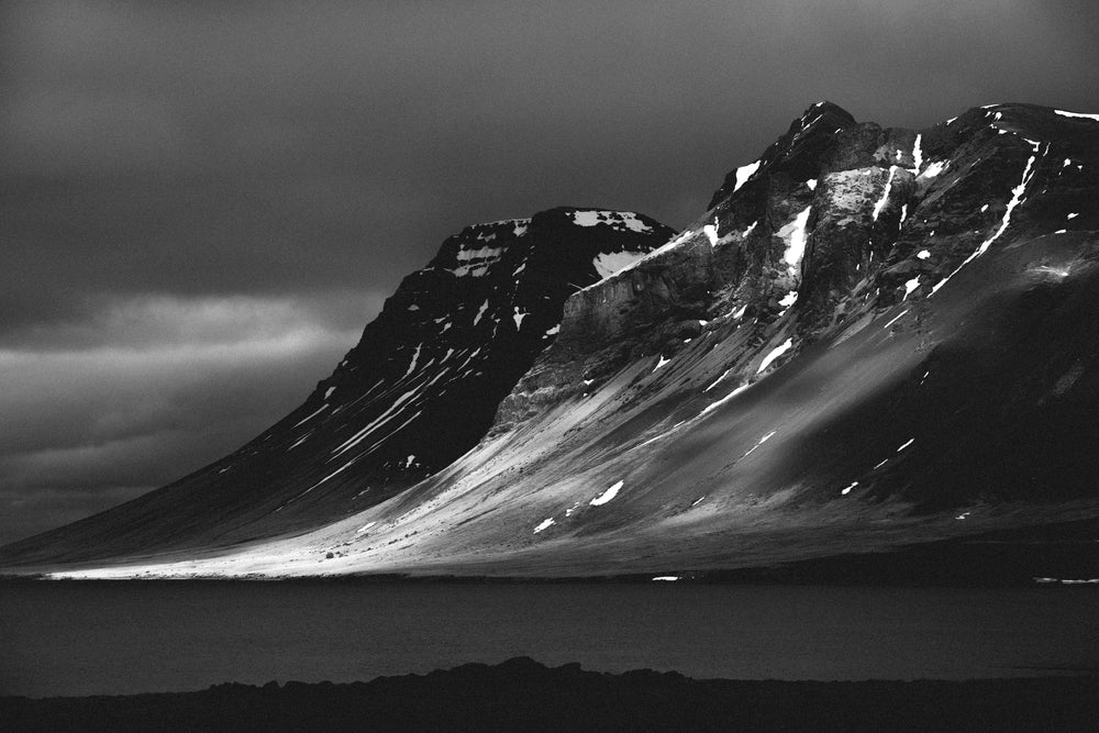 black and white mountain by the water