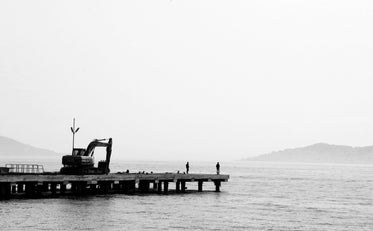 black and white photo of a dock on calm water