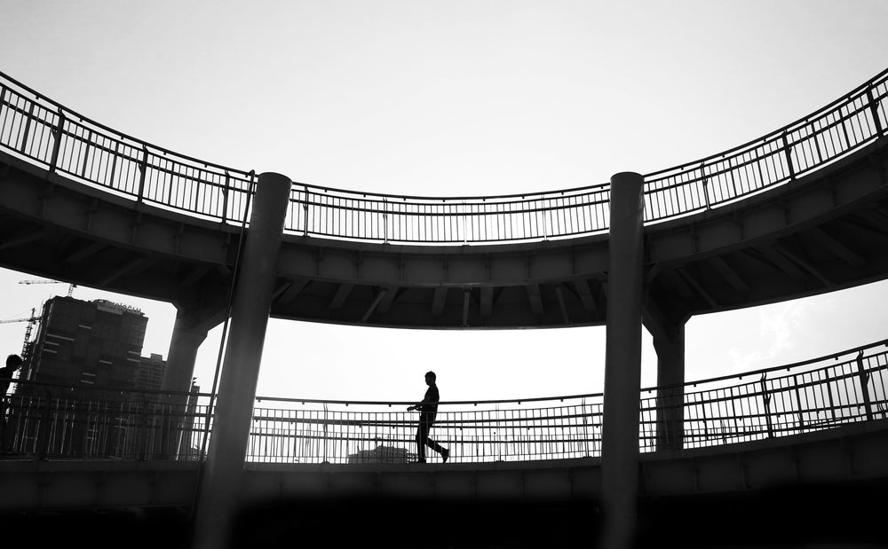 black and white photo of a person and walkway silhouetted