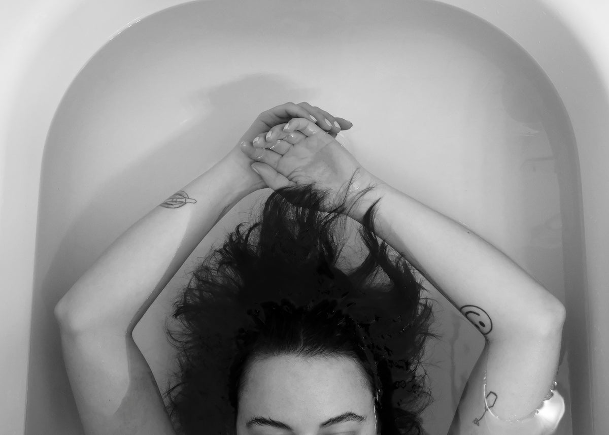 black and white photo of a persons arms in a bath