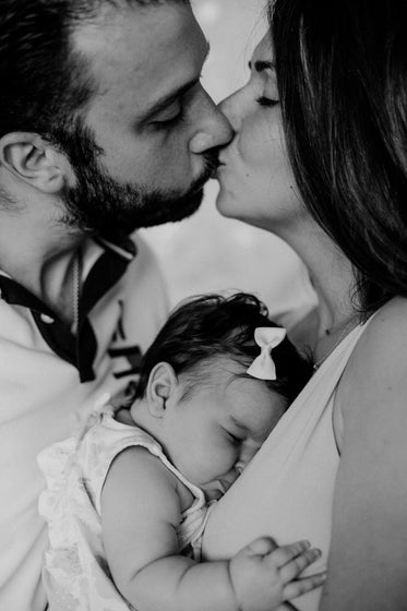 black and white photo of parents holding a baby