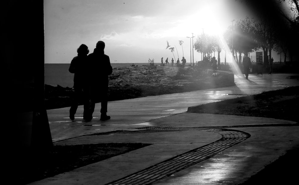 black and white photo of people on a shoreside path