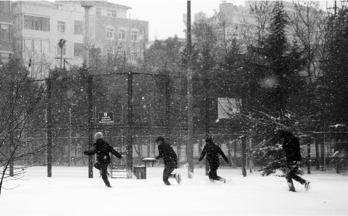人们在下雪时奔跑的黑白照片