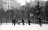 black and white photo of people running as it snows