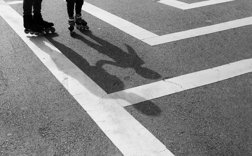 black and white photo of peoples feet wearing rollerblades