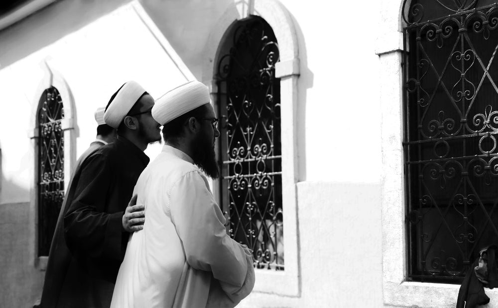 black and white photo of two people looking out a window