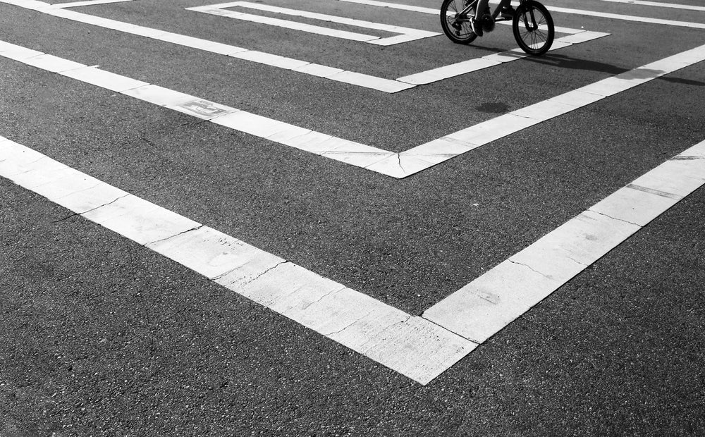 black and white photo of white lines on wet pavement