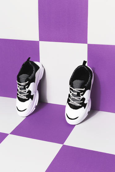 black and white sneakers against purple and white