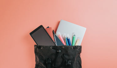 black bag lays with items for school falling out of it