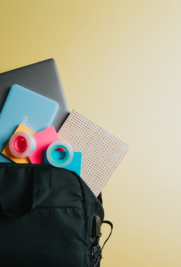 black bag with school supplies falling out of it