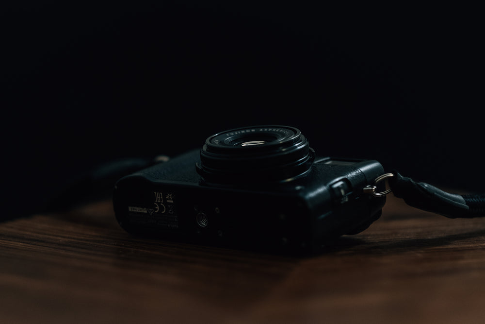 black camera lays on wooden table