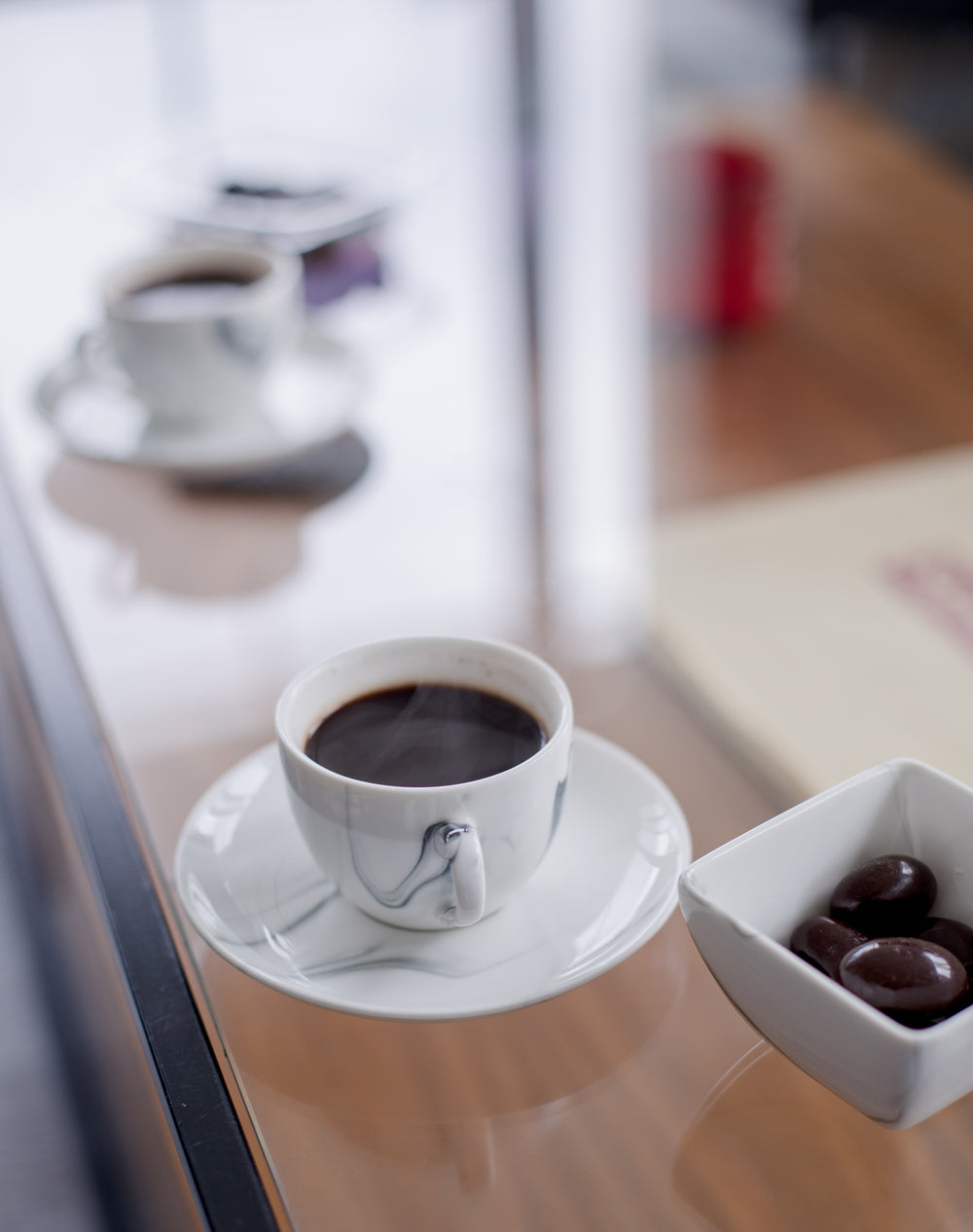 black coffee  accompanied by square bowl of olives