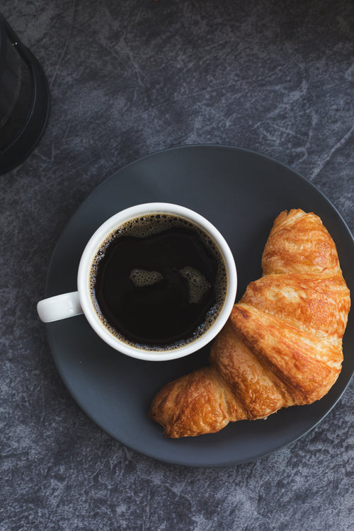 black coffee and a croissant