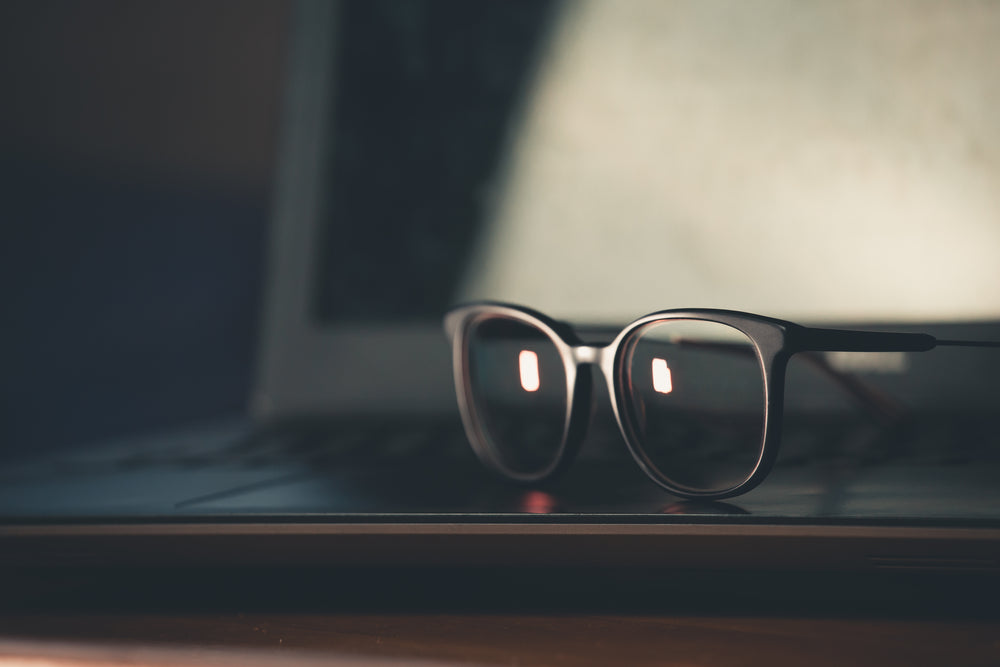 black glasses frames sit up on surface