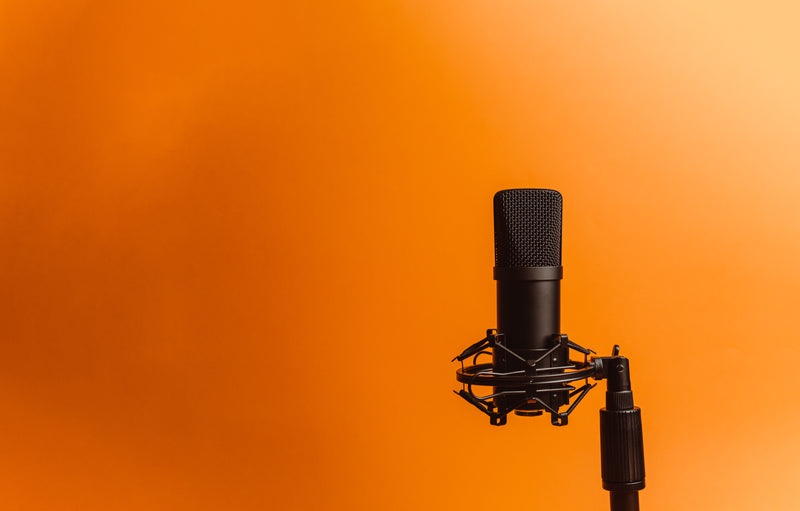 black microphone against a vibrant orange background