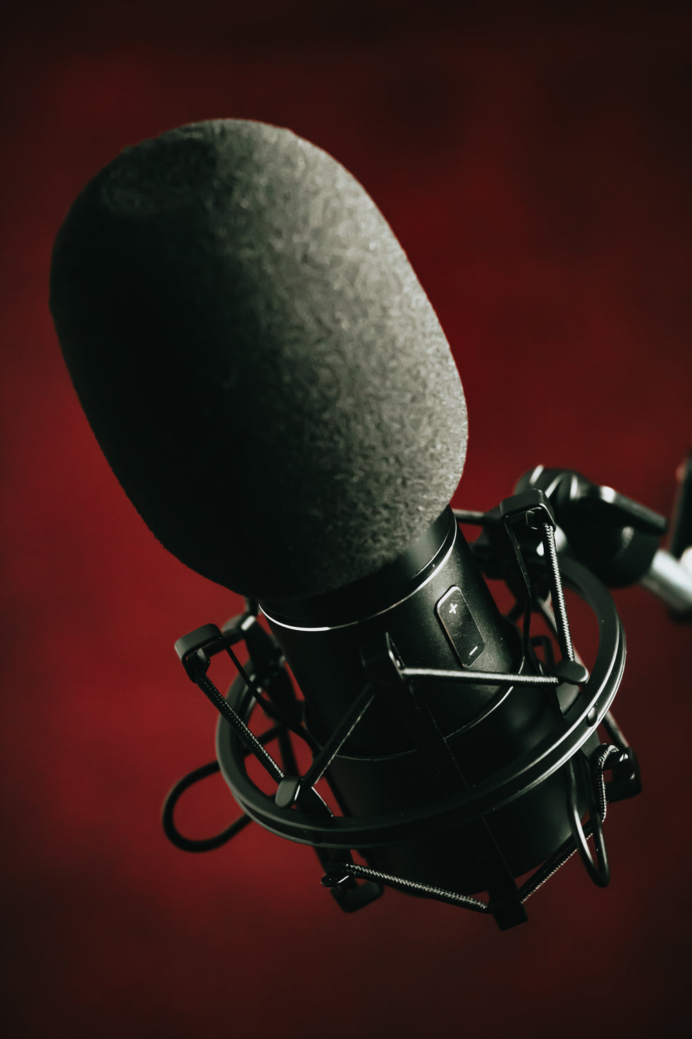 black microphone on a metal stand against deep red