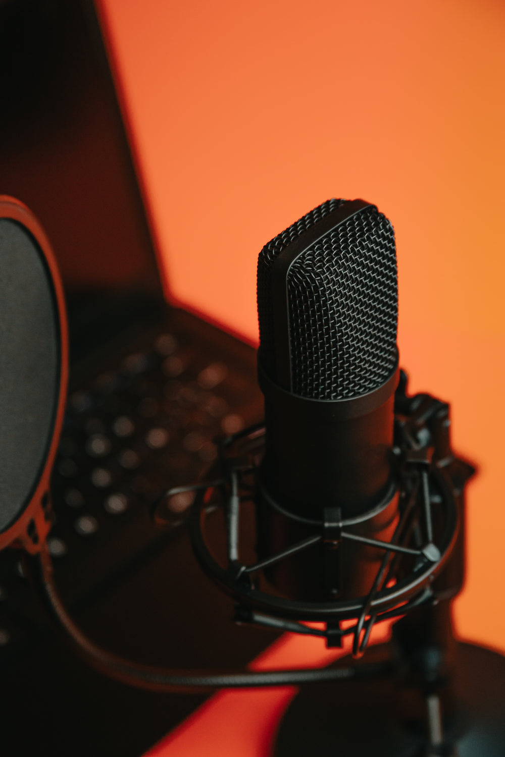 black microphone on a stand reflecting orange light