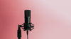 black microphone set against a pink background