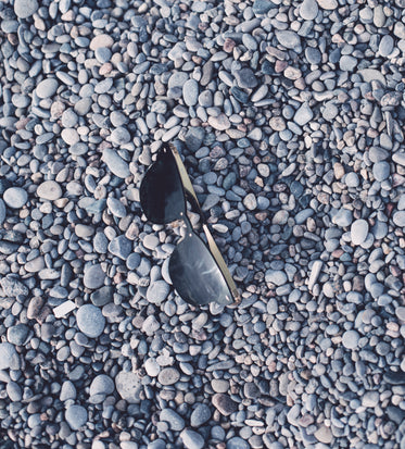 black sunglasses in a pile of grey stones