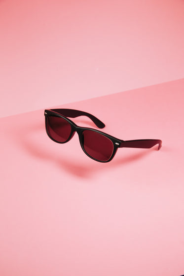 black sunglasses on pink