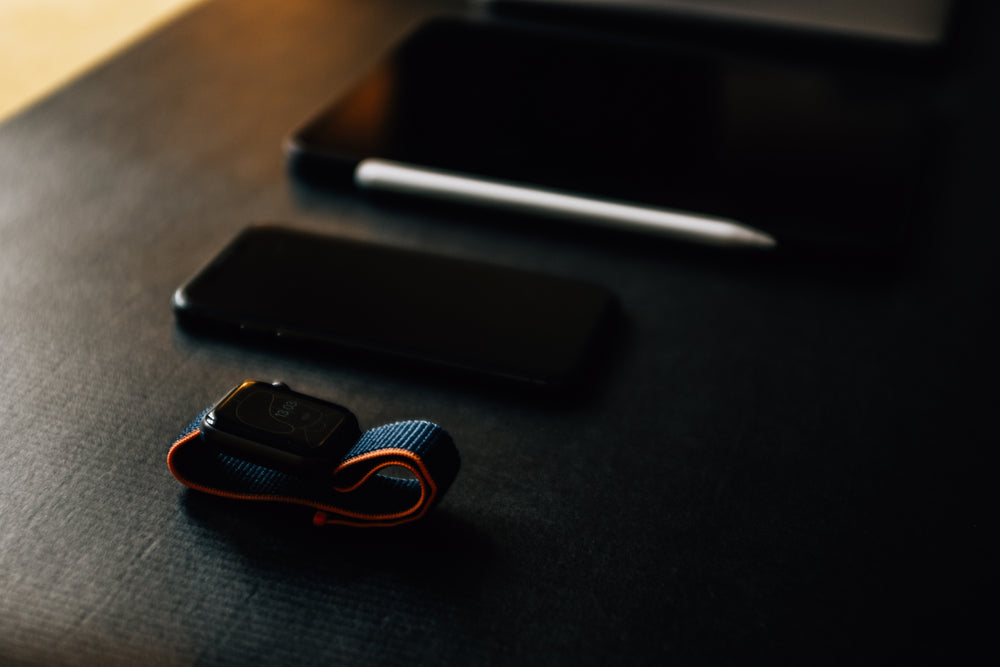 black table with a smart watch cell phone and tablet