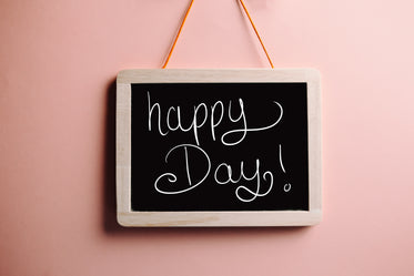 blackboard reads happy day against orange background