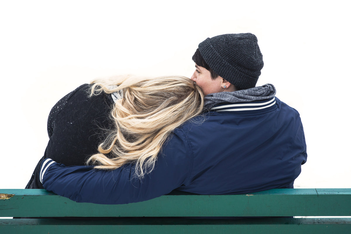 blonde woman rests her head on her partner's shoulder