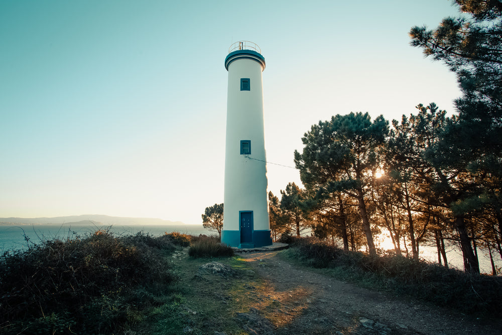 blue and white lighthouse at sunset