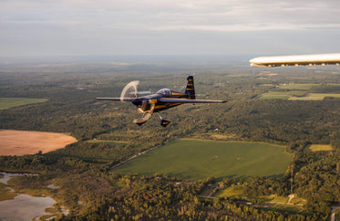 blue and yellow aerobatic plane in flight