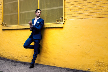blue formal suit yellow wall