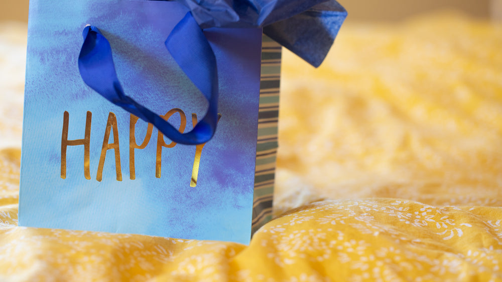 blue gift bag with gold lettering